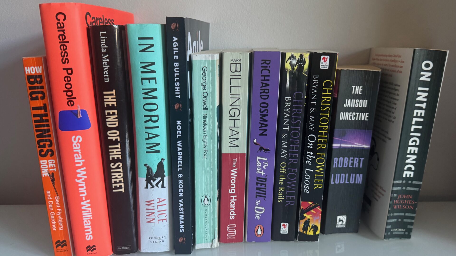 Thriller and spy novels arranged by colour on a bookshelf